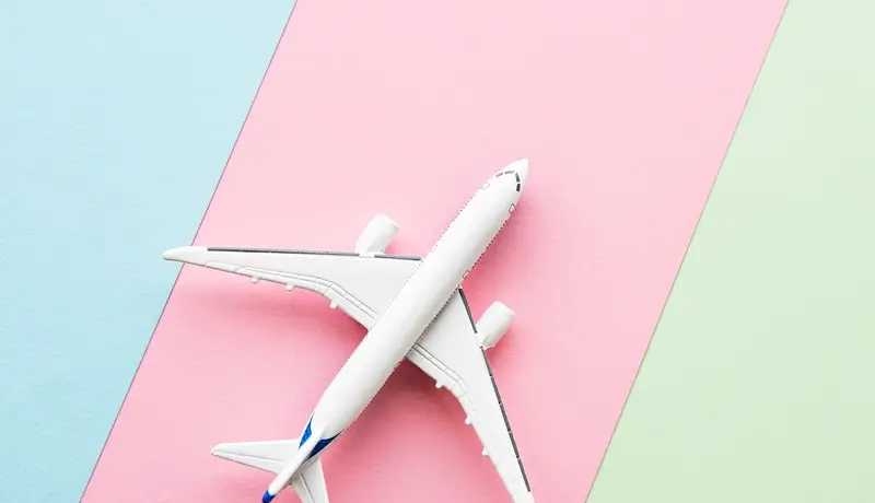 Μοντέλο αεροπλάνου σε πολύχρωμο φόντο, πιθανώς υποδηλώνοντας ταξίδια ή πτήσεις.