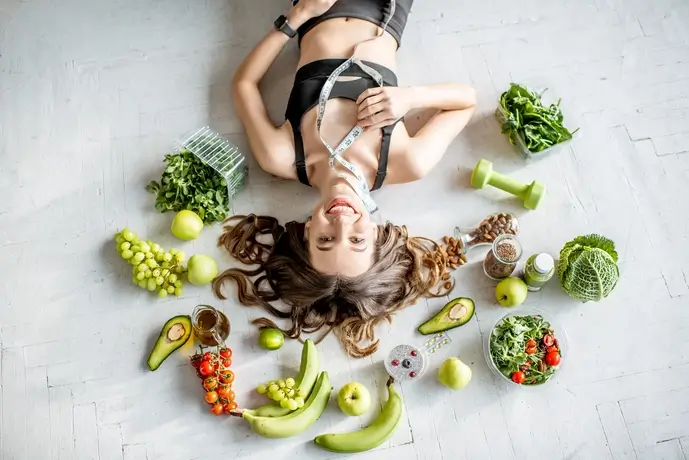 Γυναίκα με υγιεινά τρόφιμα, περιτριγυρισμένη από φρούτα και λαχανικά.