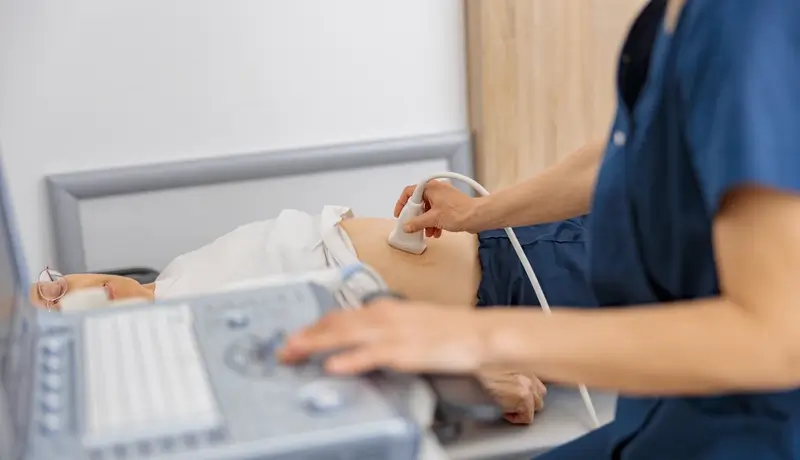 Medical professional performing an abdominal ultrasound scan on a patient.