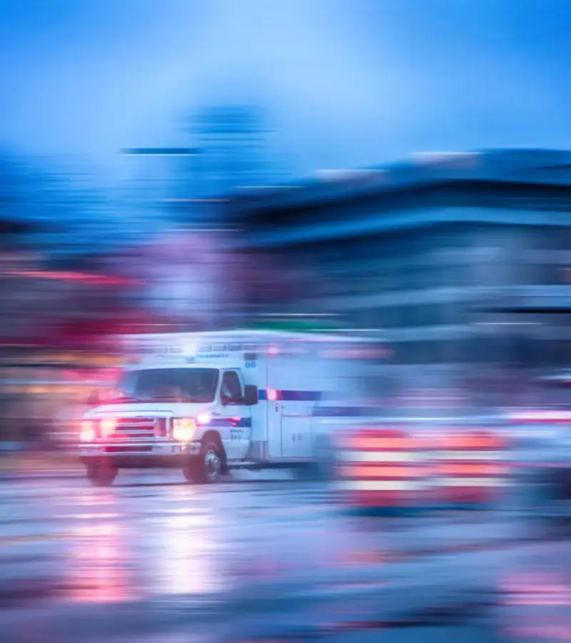 Ασθενοφόρο σε κίνηση, συμβολίζοντας την άμεση ιατρική φροντίδα για υπηρεσίες κατ' οίκον νοσηλείας.