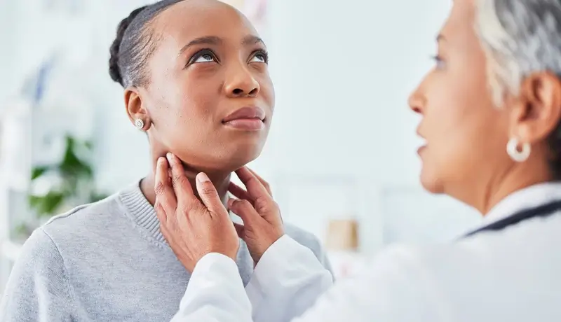 Doctor examining a patient's thyroid gland