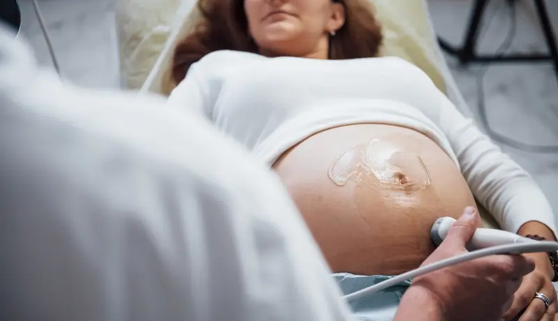 Male doctor does ultrasound for a pregnant woman in the hospital