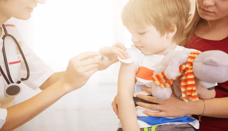 Παιδί λαμβάνει εμβόλιο και κρατάει παιχνίδι