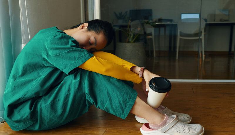 Resting Nurse in Hospital Break Room Holding Coffee Mug