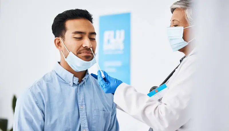 Γιατρός πραγματοποιεί ρινοφαρυγγικό τεστ σε ασθενή