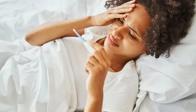 A lady not feeling well and having a high temperature