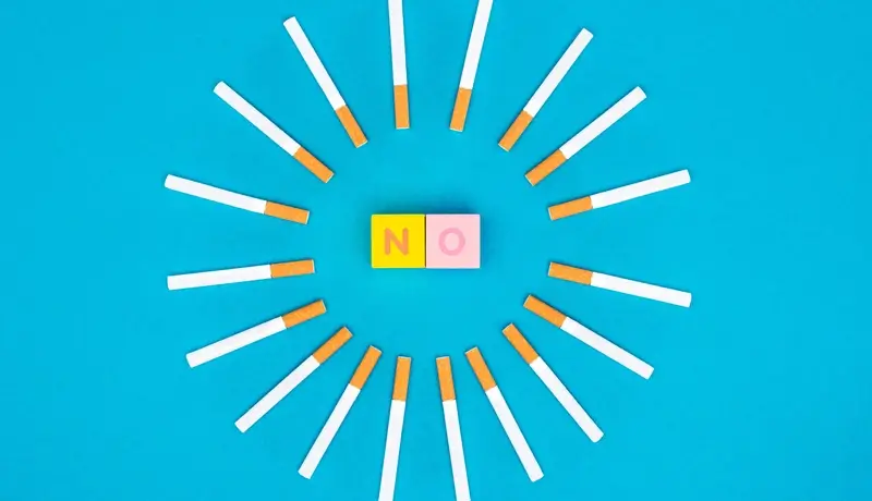  Cigarettes arranged in a circular pattern with a "NO" block, symbolizing the impact of smoking on phlegm production.