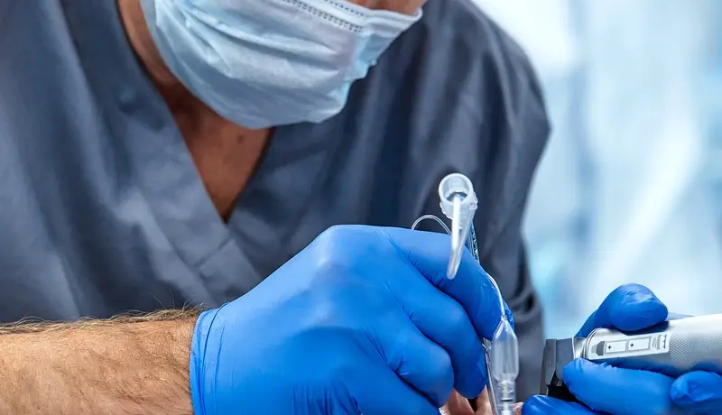 Medical professional performing tracheal intubation with specialized equipment.