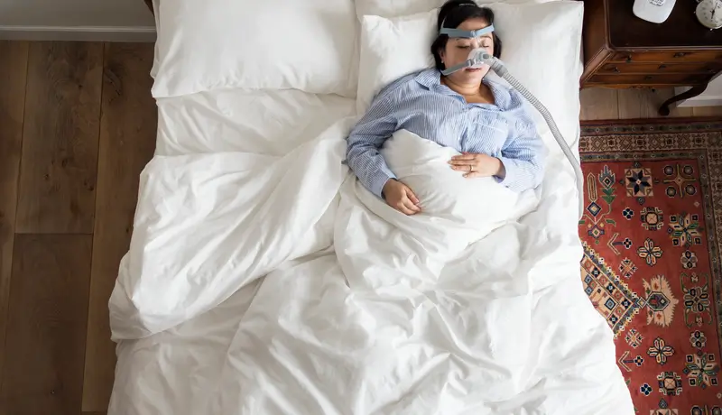 A woman sleeping with an anti-snoring mask