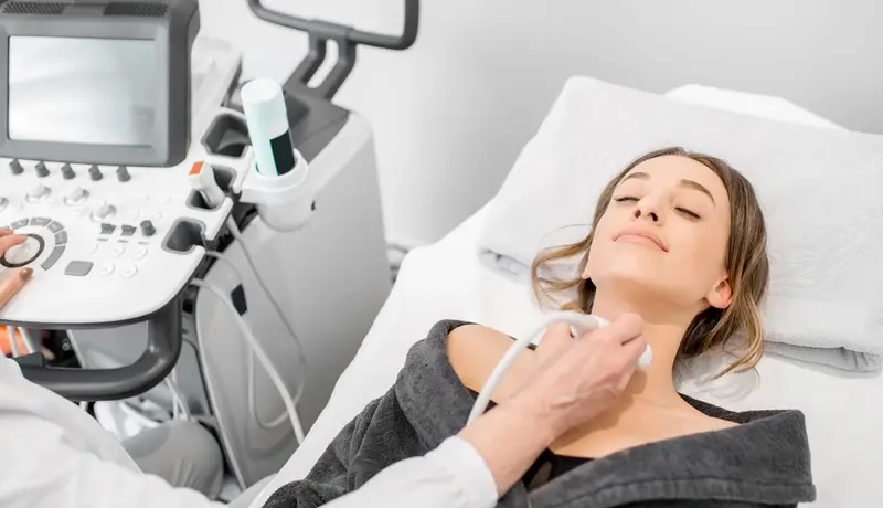 Woman undergoing a thyroid ultrasound scan
